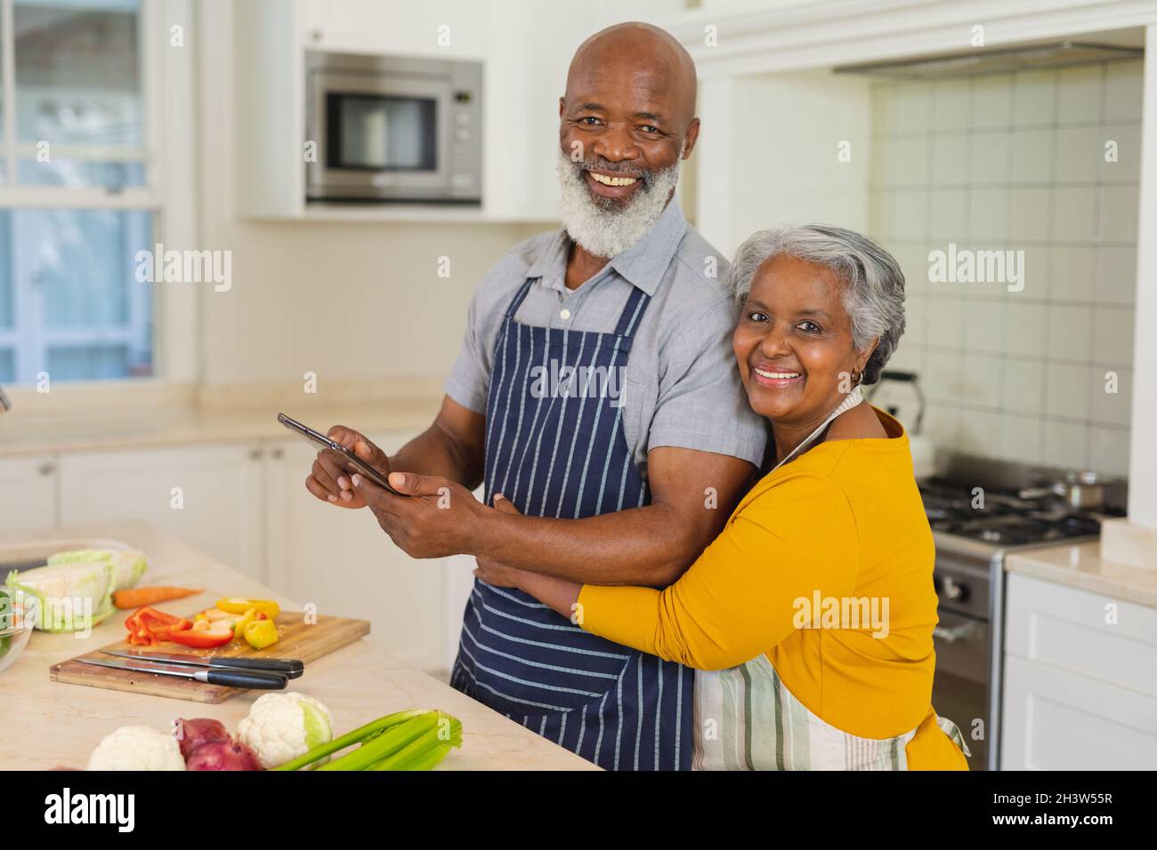Portrait of senior african american couple cooking together in kitchen ...