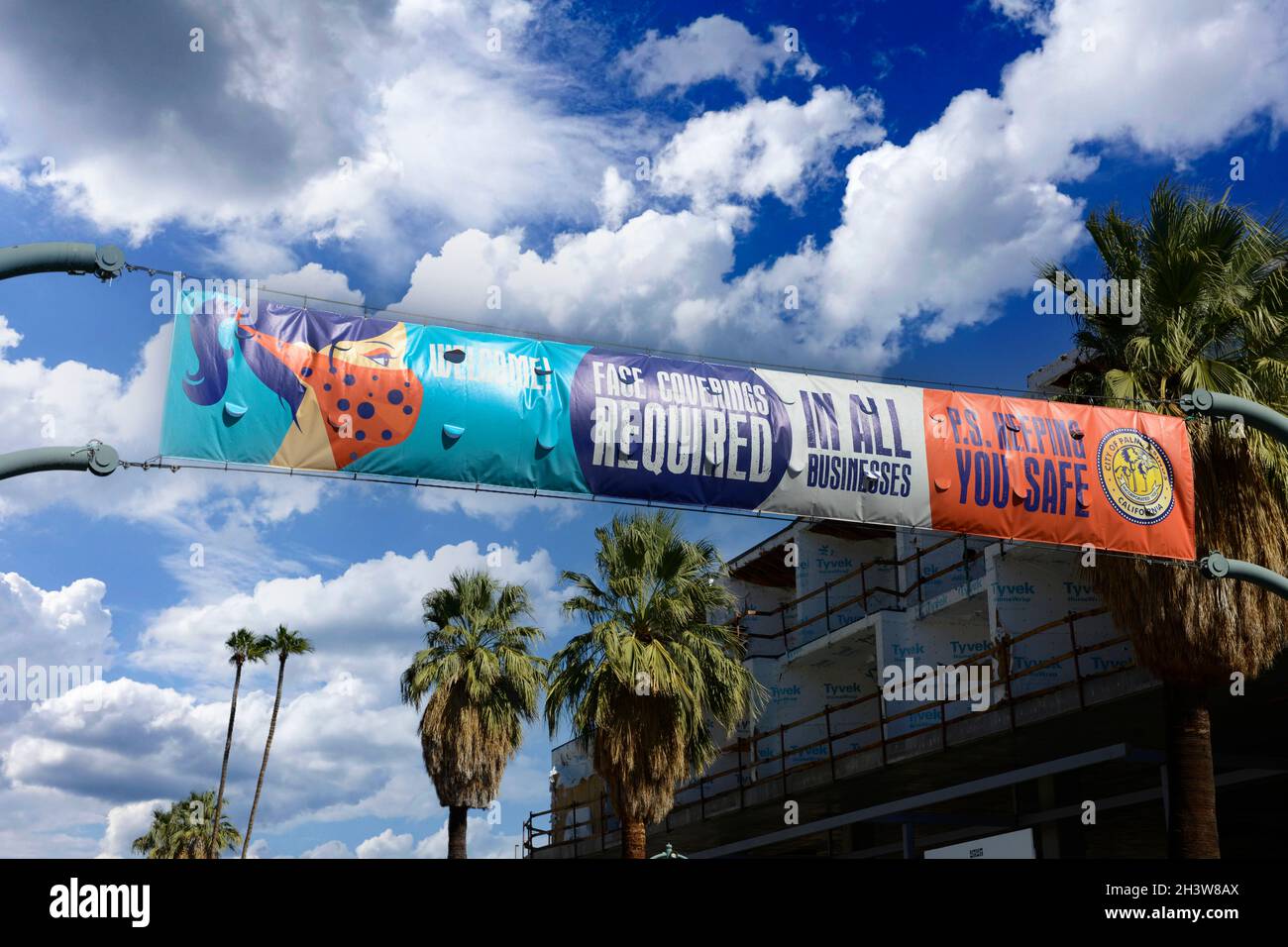 Overhead banner on N Palm Canyon Dr informing people that masks are required in all businesses in Palm Springs Stock Photo