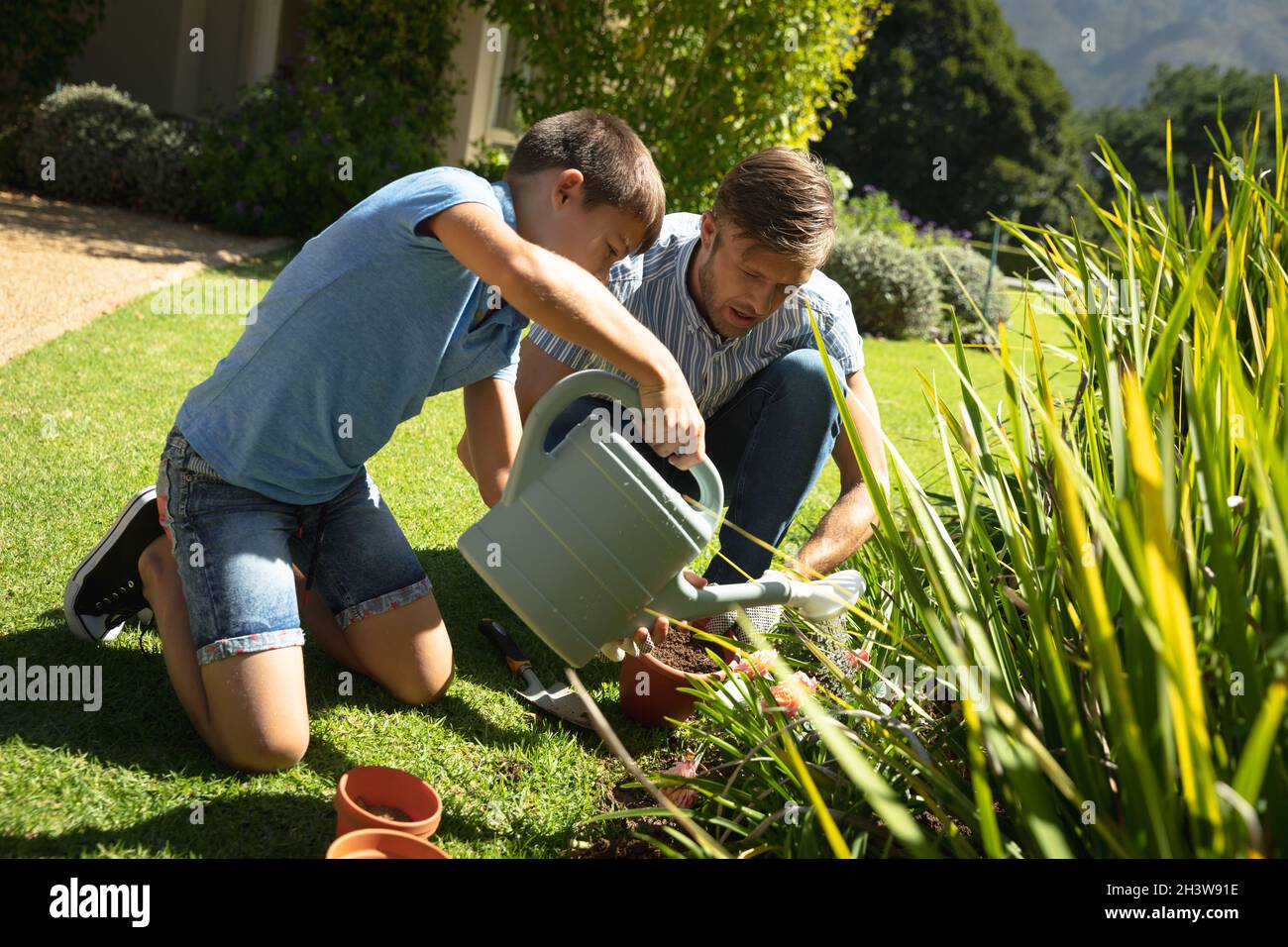 Happy caucasian father and son outdoors, gardening on sunny day Stock ...