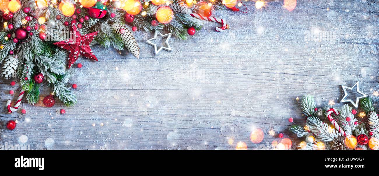 Christmas Decoration - Ornament With Fir Branches And Snow On Blue Wooden Table With Defocused Lights Stock Photo