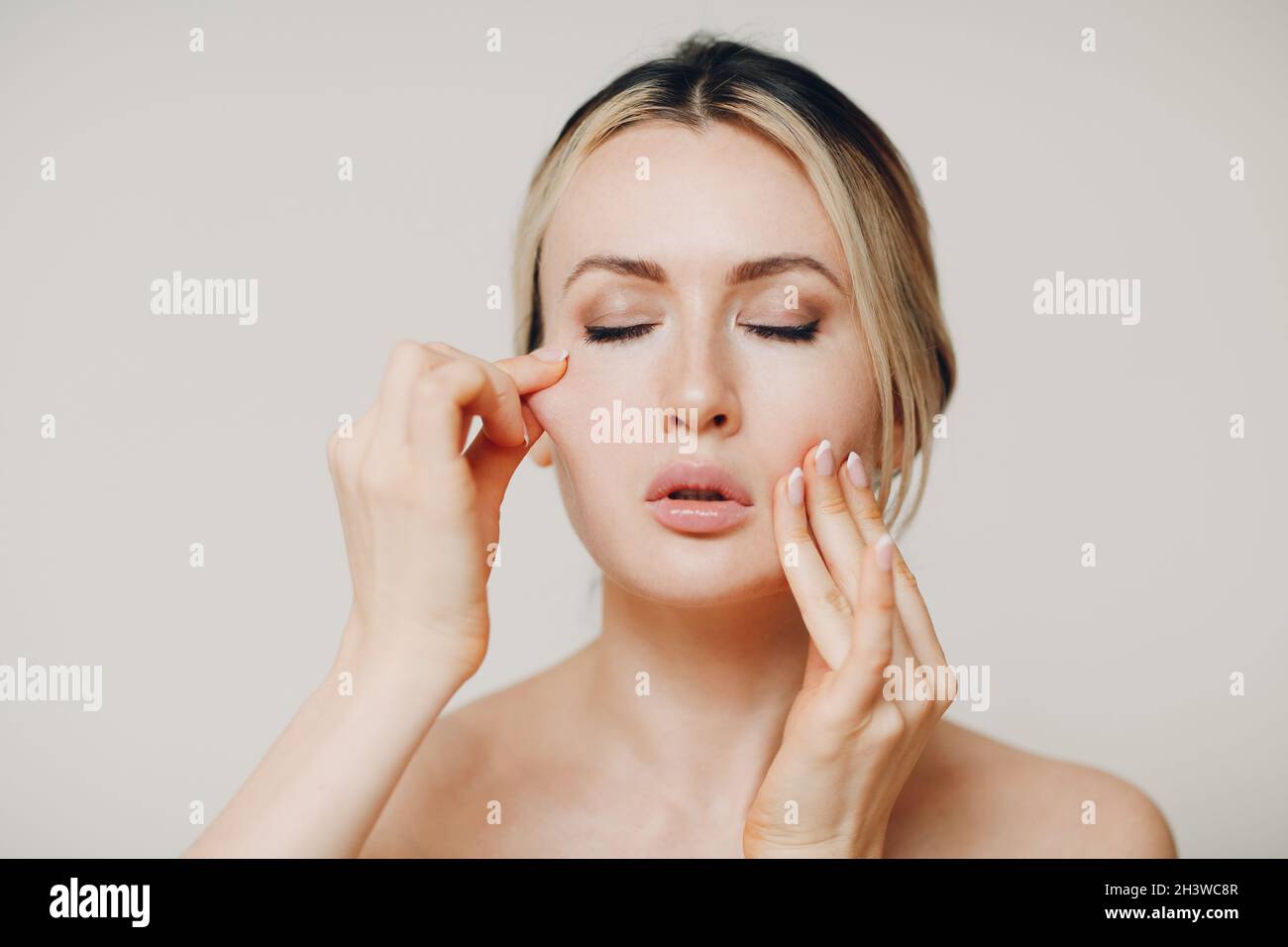 Woman doing facial gymnastics self yoga massage and exercises for face skin. Stock Photo