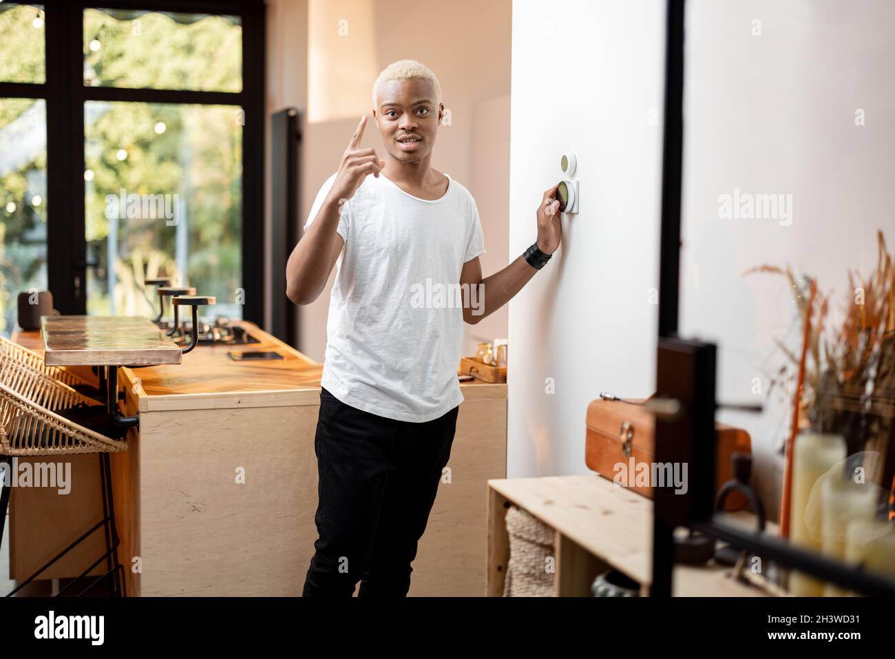 Latin man choosing temperature on thermostat Stock Photo