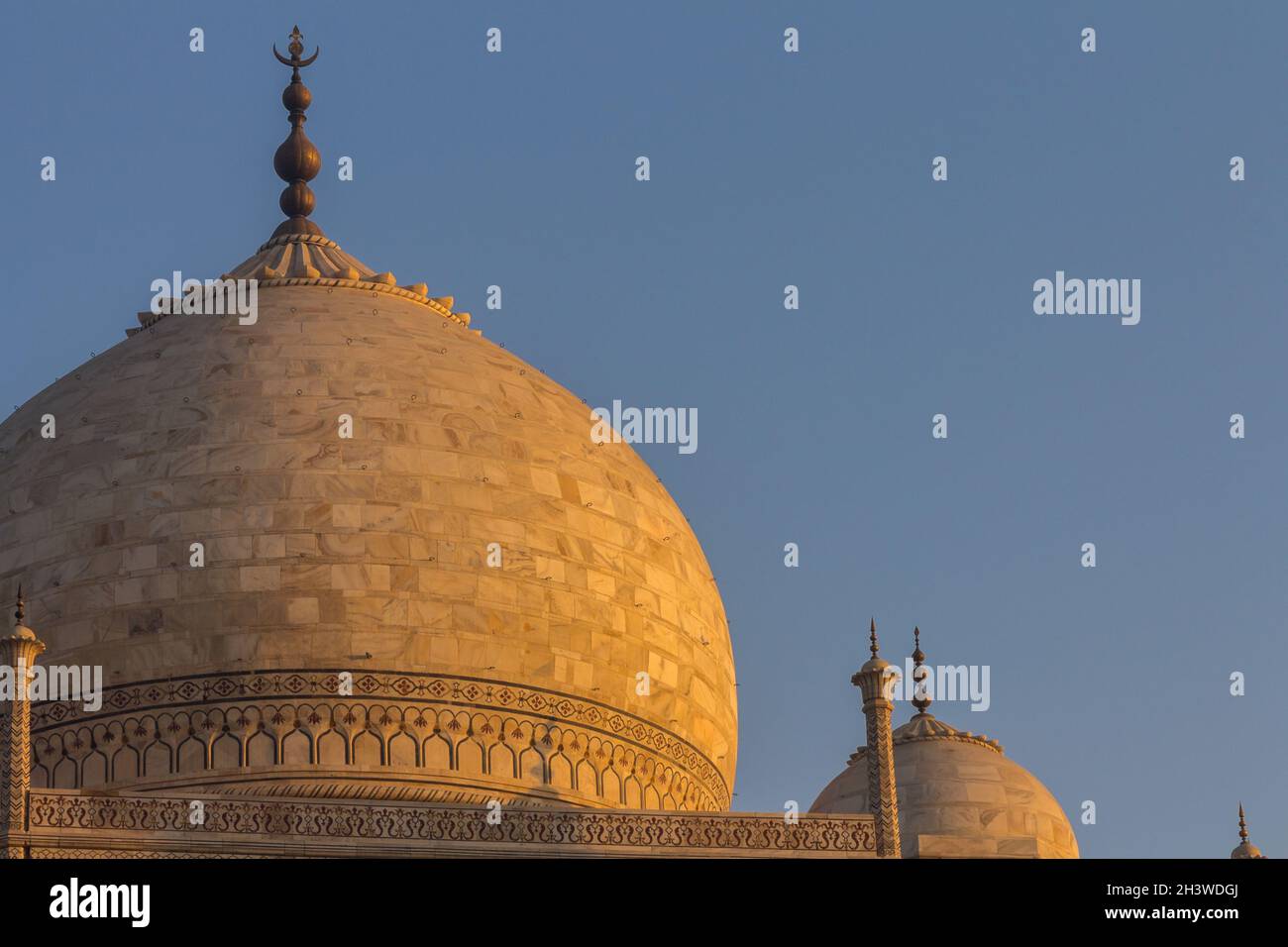 Taj Mahal's dome lit by the golden light of the rising sun Stock Photo