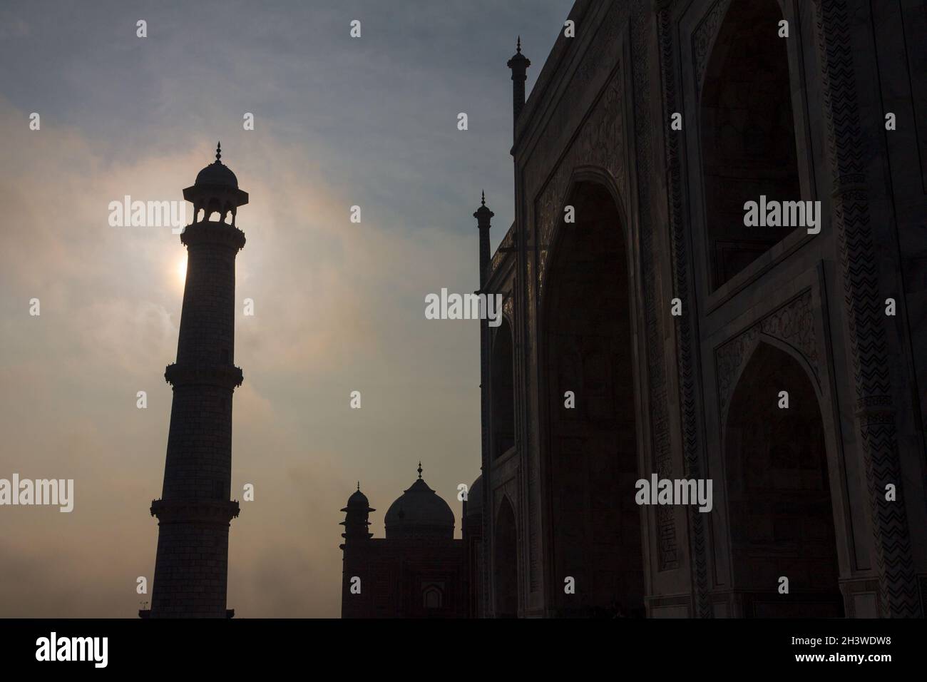 Taj Mahalâ€™s minaret backlit by the early morning sun Stock Photo
