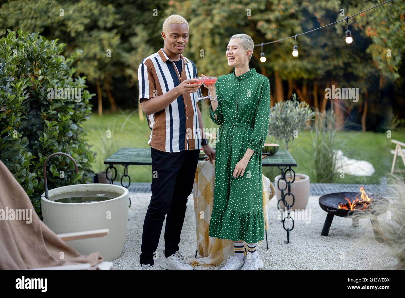 Multiracial couple having a dinner at their backyard Stock Photo