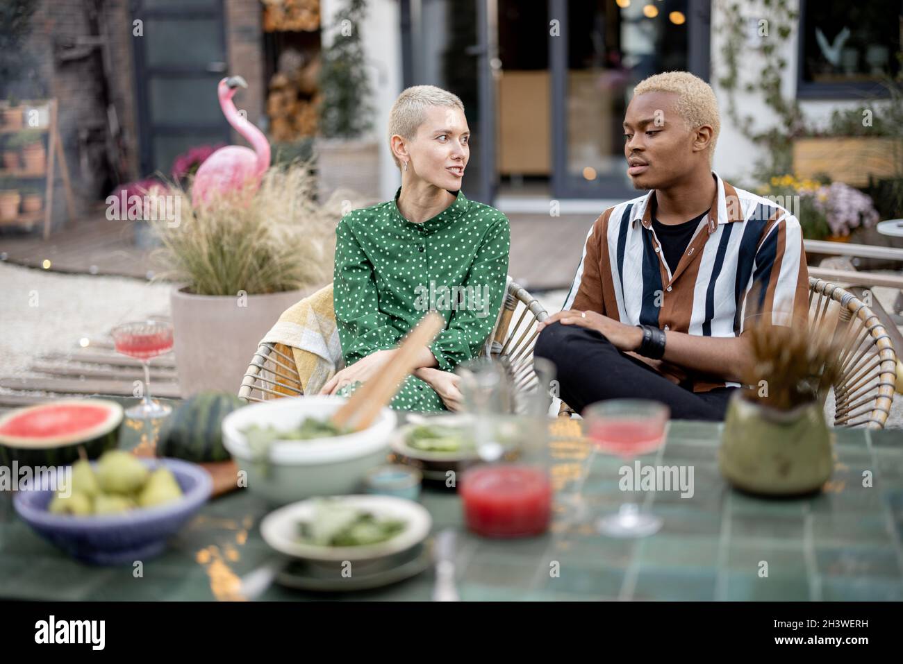 Multiracial couple having dinner at their backyard Stock Photo