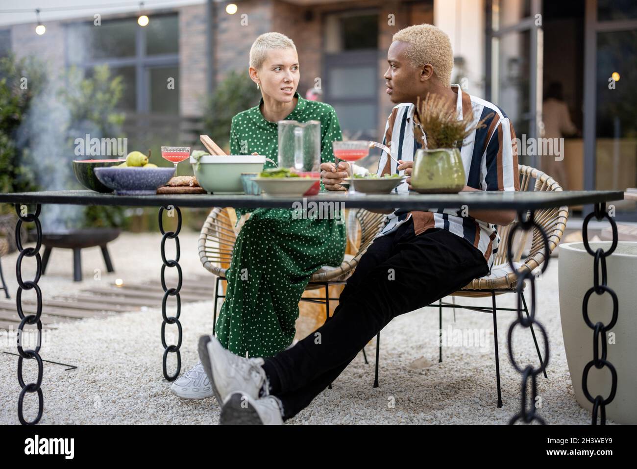 Multiracial couple having dinner at their backyard Stock Photo