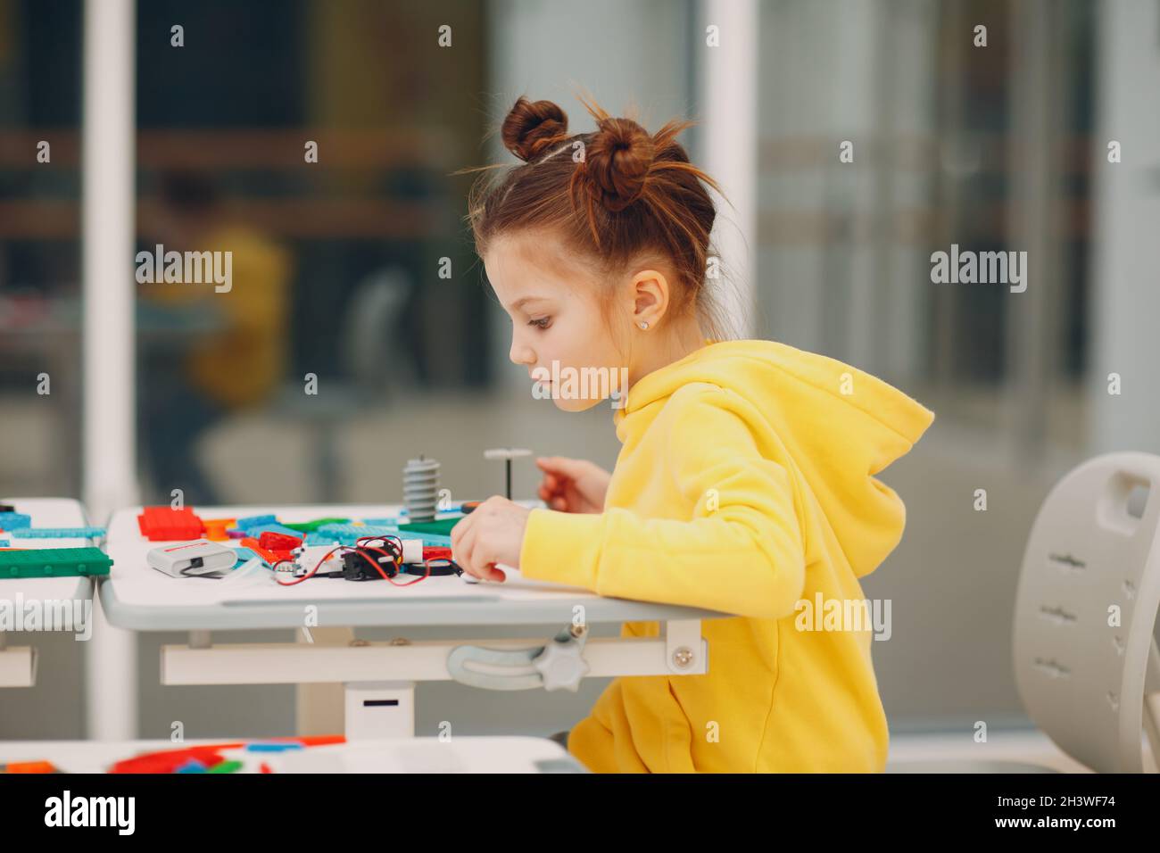 Little girl kid child constructor checking technical toy. Children Robotics constructor assemble robot. Stock Photo