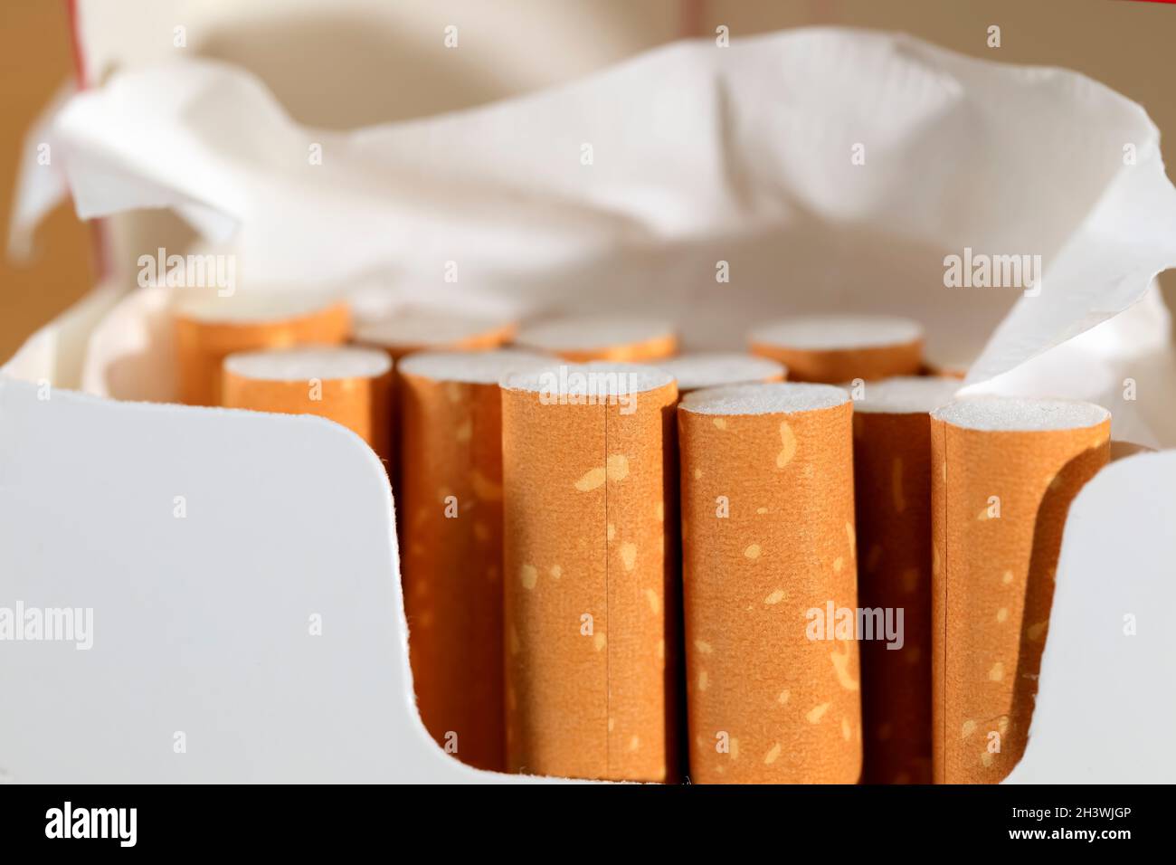 Several cigarettes in an already open pack. These are filter cigarettes. Stock Photo