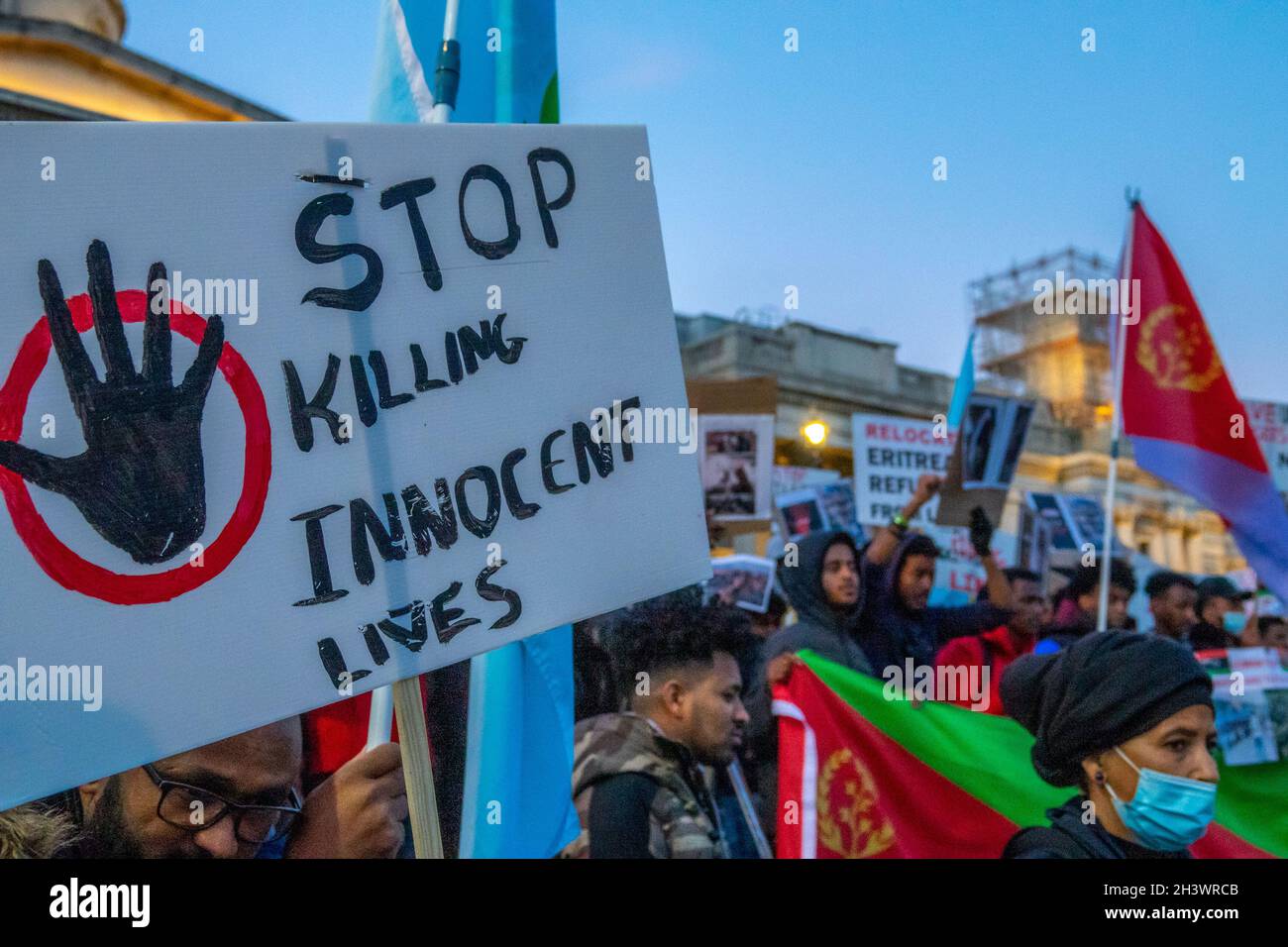 A crowd of protesters on Trafalgar Square, London, waving flags and placards stating 'Stop killing innocent lives' in protest against alleged human rights abuse of refugees from Eritrea. Stock Photo