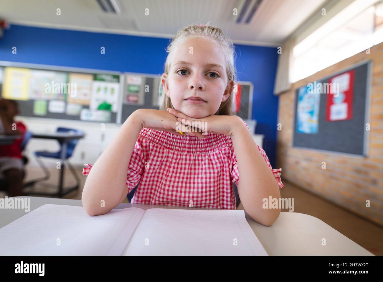 Portrait of caucasian girl sitting on her desk in the class at ...