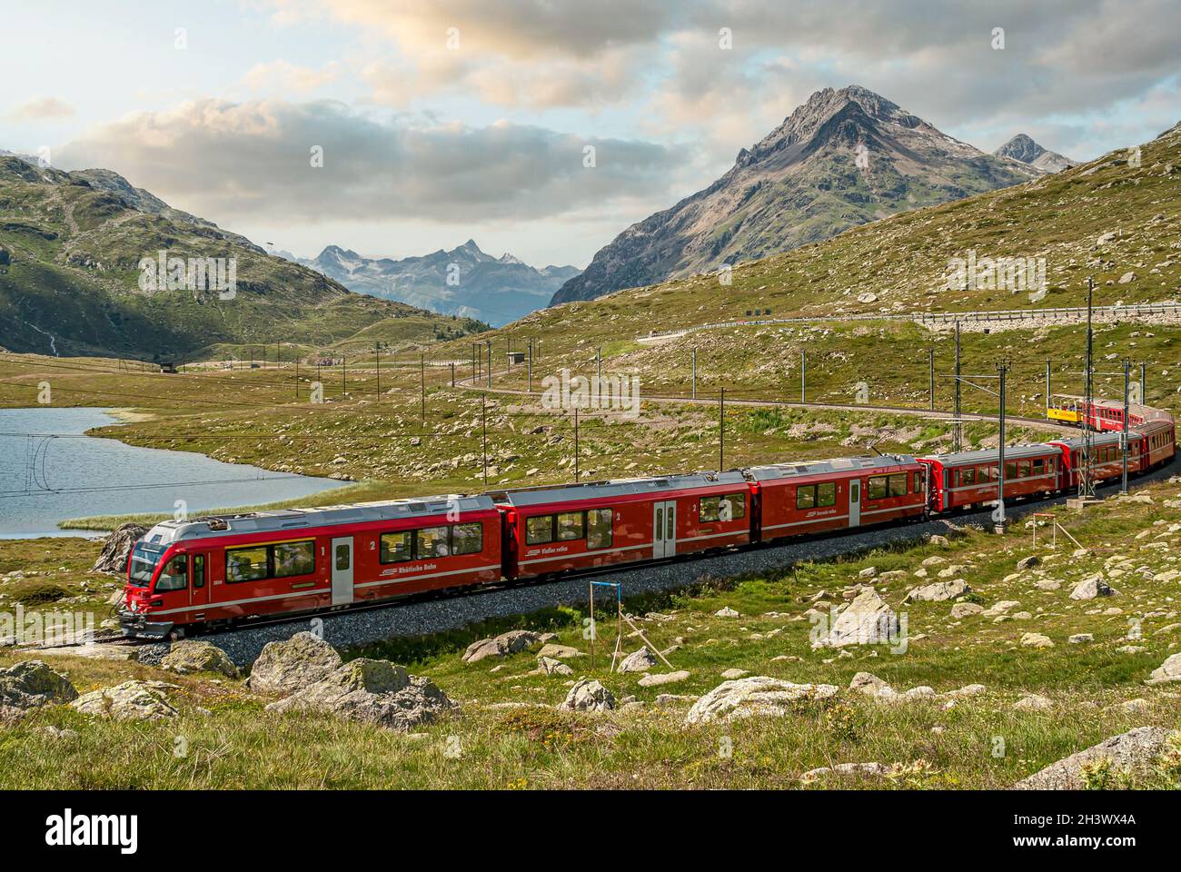 Alpine train at Lago Bianco at the Bernina Pass in the Swiss Stock Photo