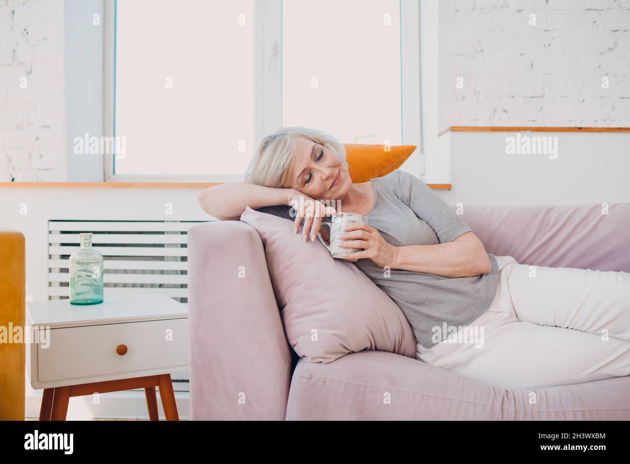 Elderly caucasian old aged woman enjoying afternoon tea at home. Stock Photo