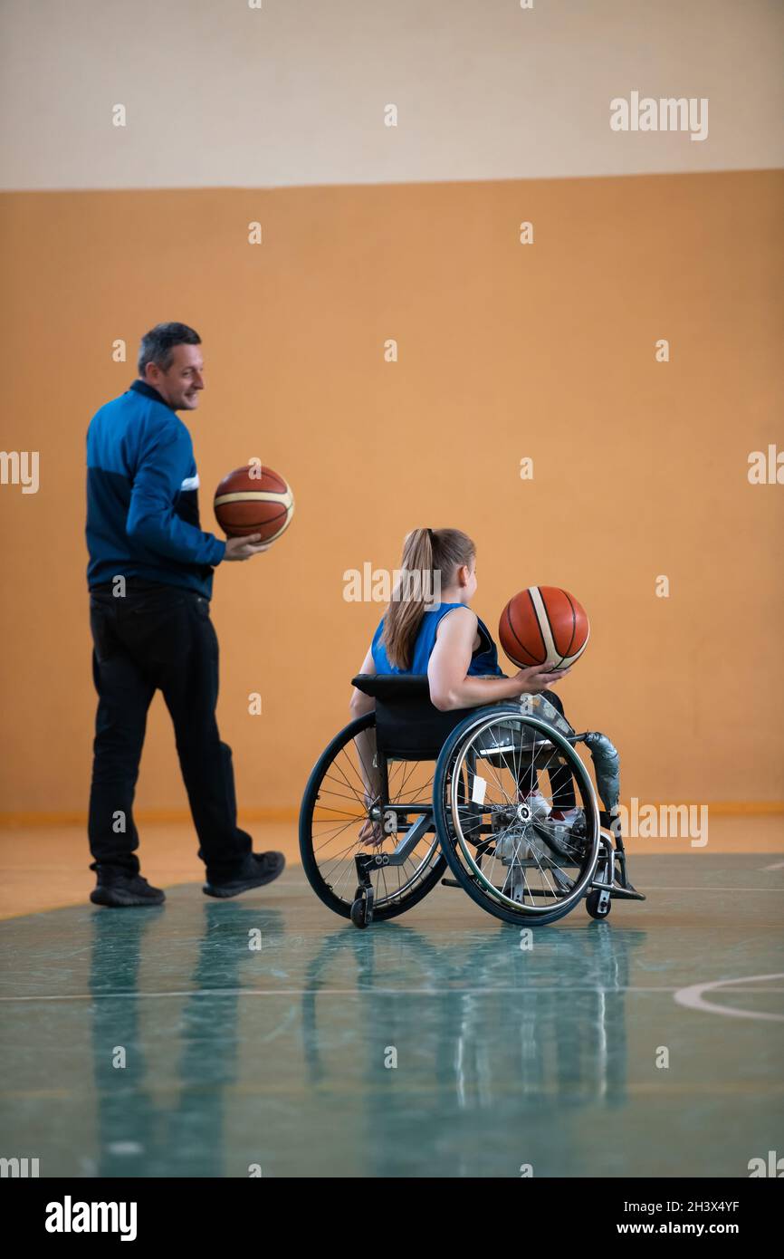 A sports basketball coach explains to a disabled woman in a wheelchair