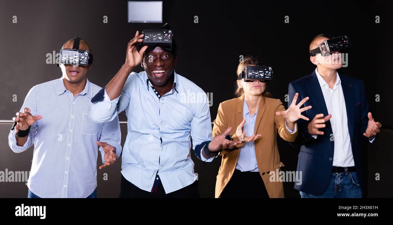 Cheerful nice friends playing video games using virtual reality glasses Stock Photo
