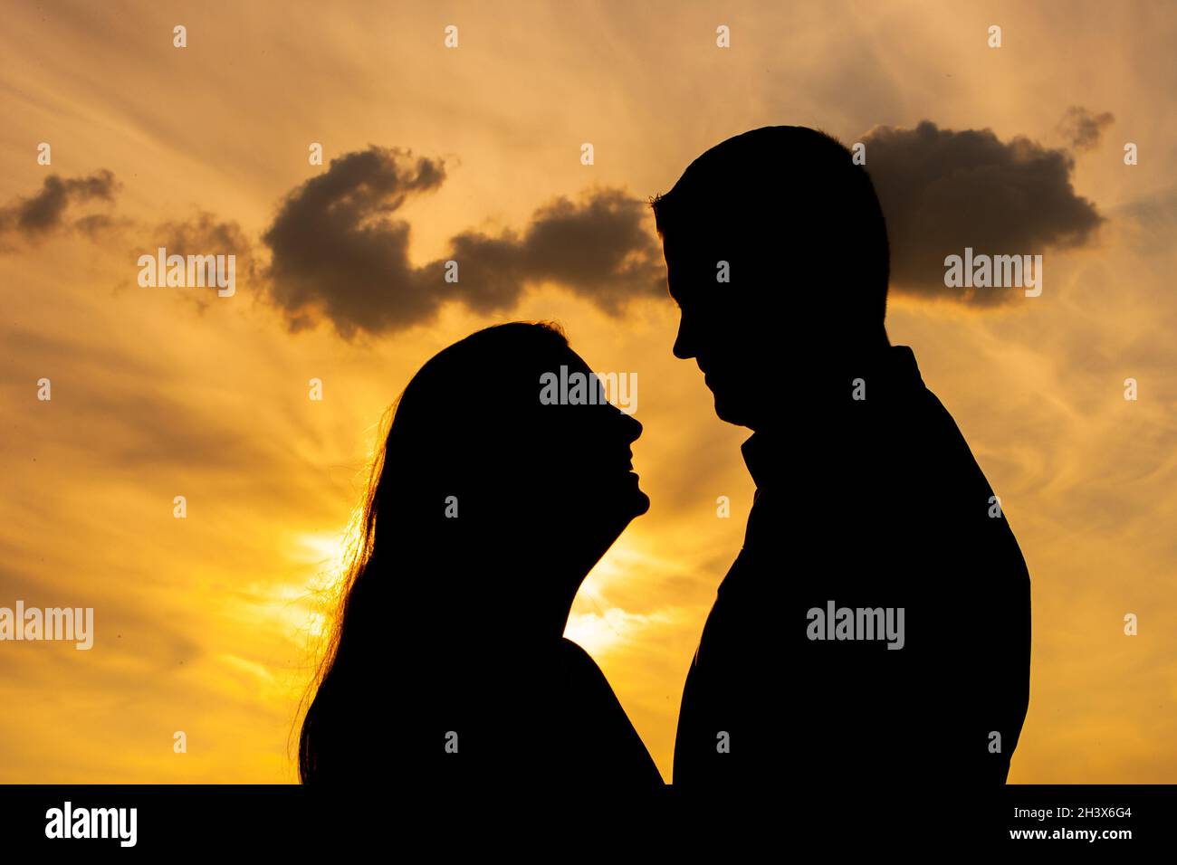 Silhouette of a couple in love during sunset Stock Photo