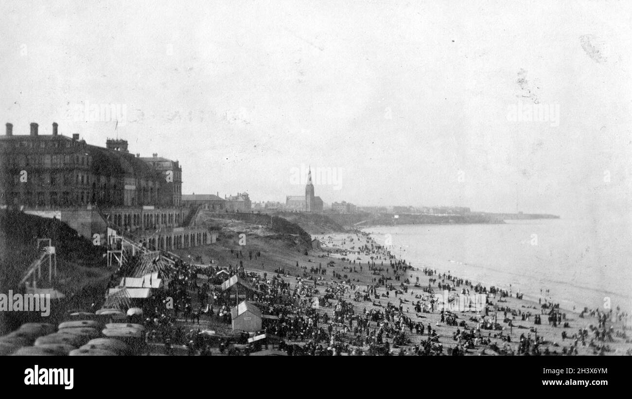A crowded Long Sands beach at Tynemouth, England,  March 28, 1910. The building on the left is the Tynemouth Palace (later the Tynemouth Plaza, destroyed by fire in 1996). Stock Photo