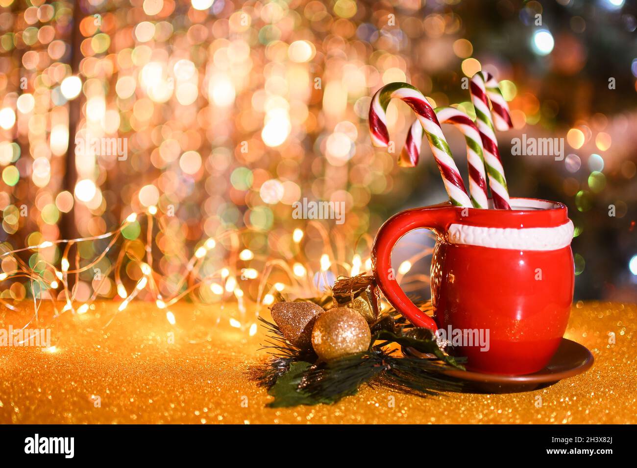 Red cup on a saucer with candy cane. copyspace Stock Photo