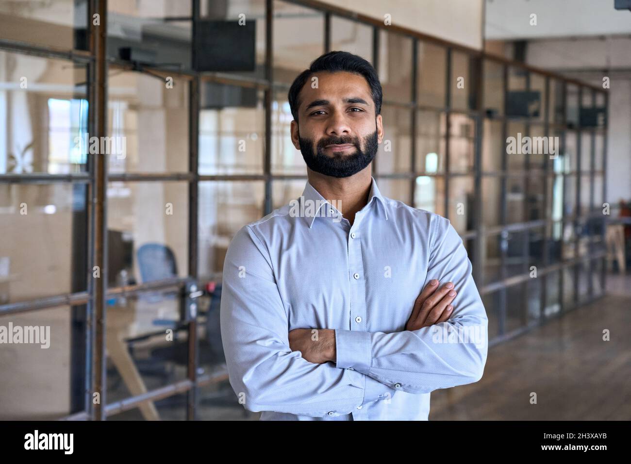 Confident successful indian businessman looking at camera standing in office. Stock Photo