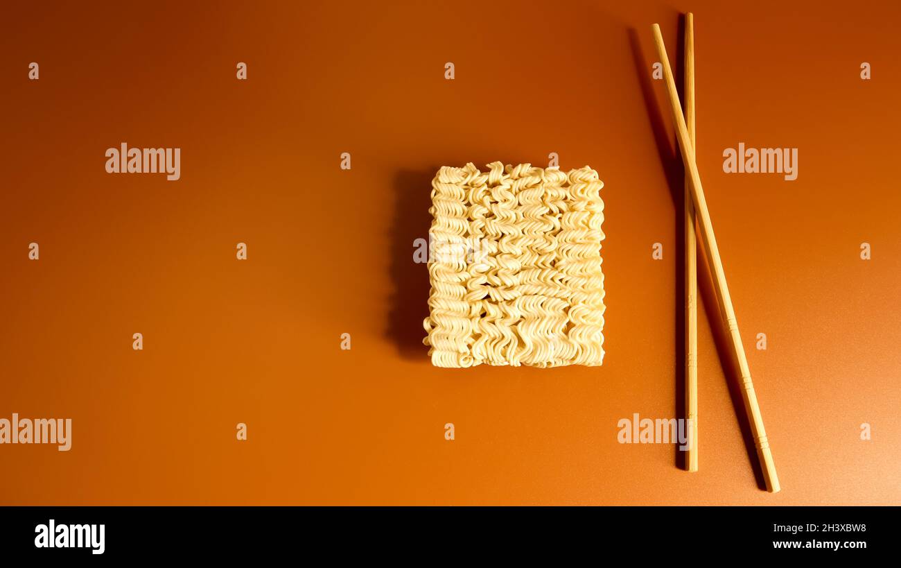 Raw dried instant noodles with chopsticks with copy space. Asian food. minimalism. pasta, for the preparation of which it is eno Stock Photo
