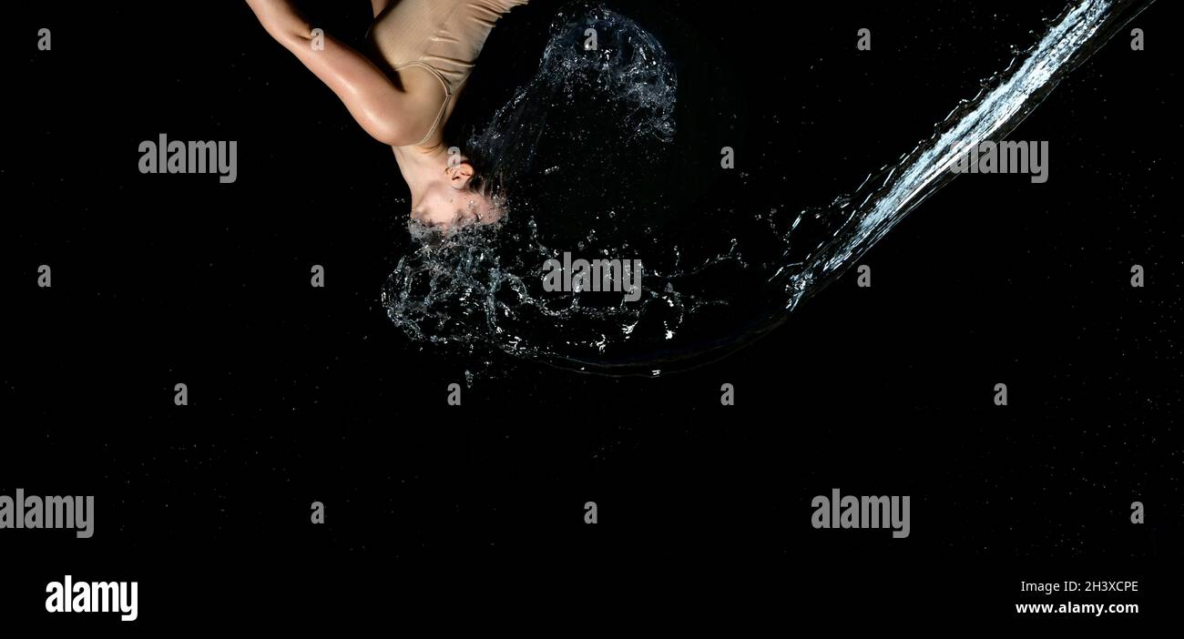 Beautiful woman of Caucasian appearance with black hair in drops of water on a black background Stock Photo