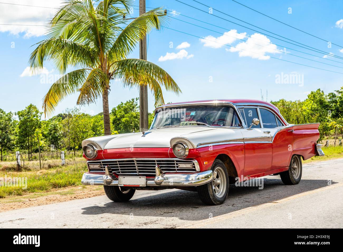 Old white-red classic american retro car on the road in countryside, Trinidad, Cuba Stock Photo