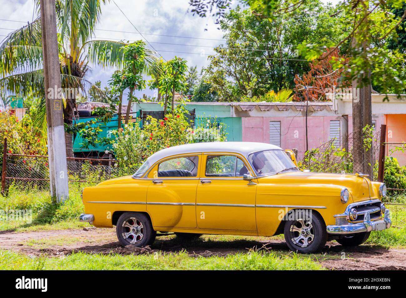 Old yellow american retro car parked in the countryside, Ciego De Avila, Cuba Stock Photo