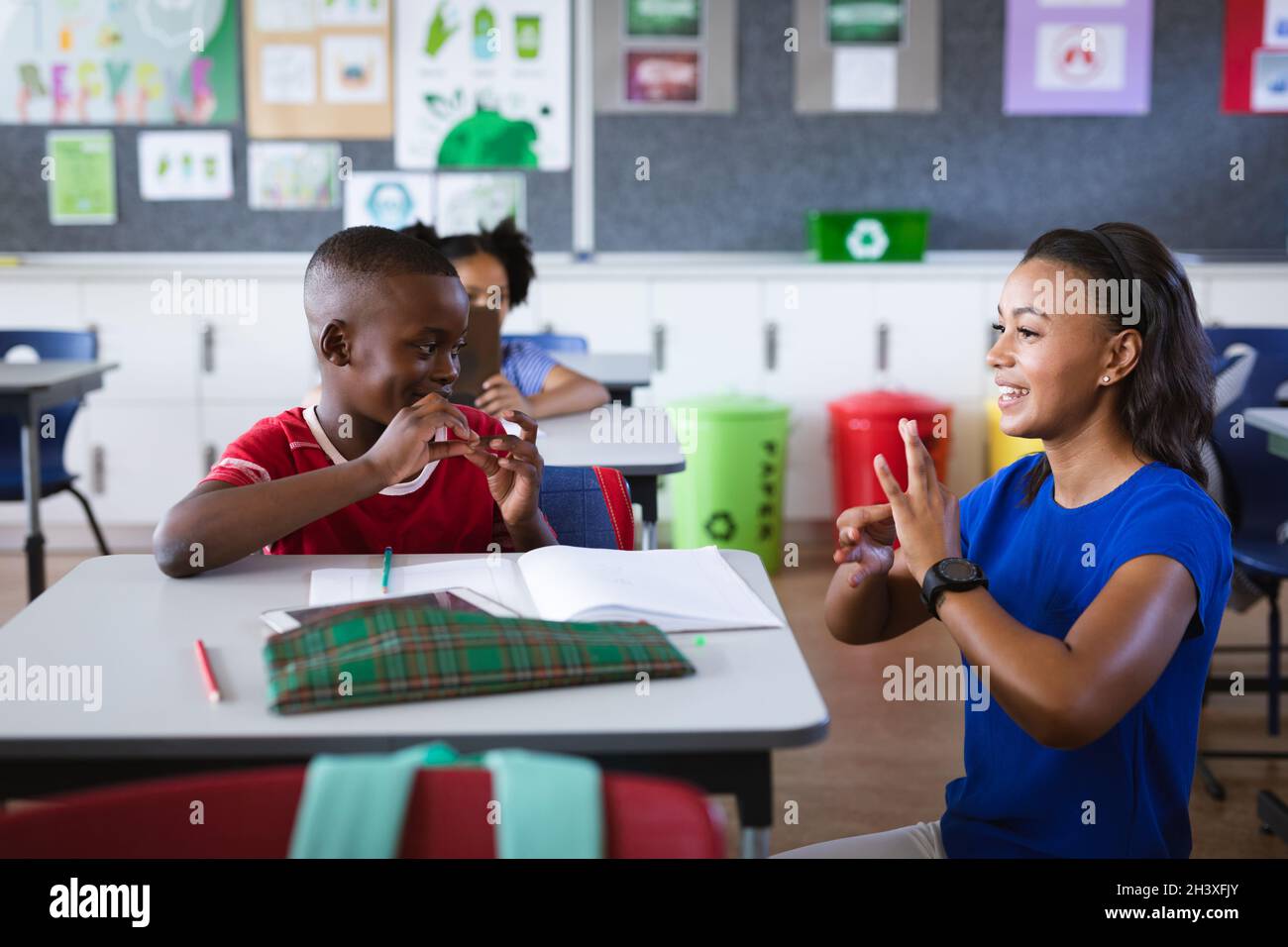 African american female teacher and boy talking in hand sign language at elementary school Stock Photo
