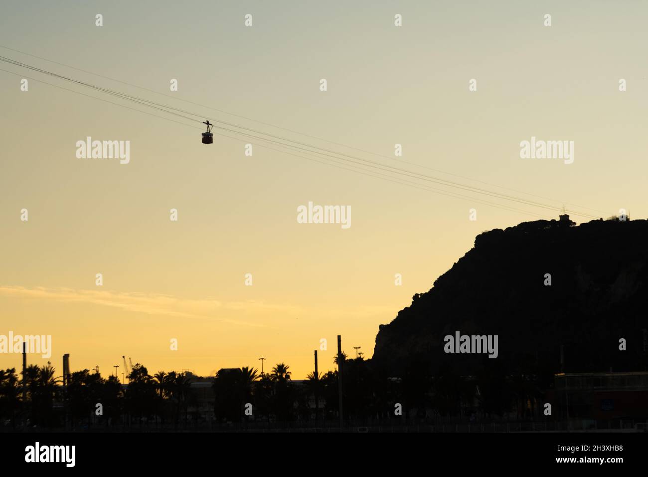Overhead cable car on sunset. Trolley silhouette. Sunset photography. Ropeway. Stock Photo