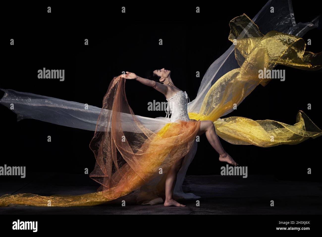 Beautiful woman of Caucasian appearance with black hair dances on a black background Stock Photo