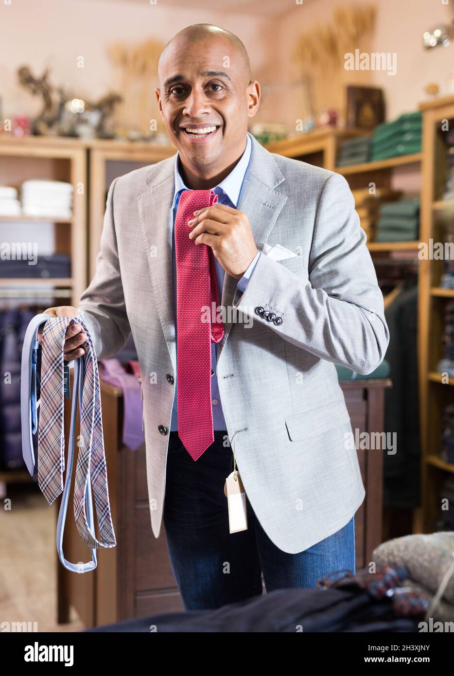 Man choosing new tie in clothing boutique Stock Photo - Alamy