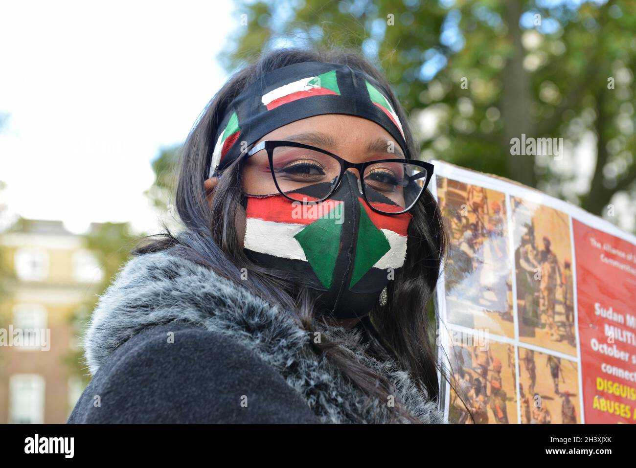 A protester wearing a face mask with the colors of a Sudanese flag takes part during the demonstration. Stock Photo