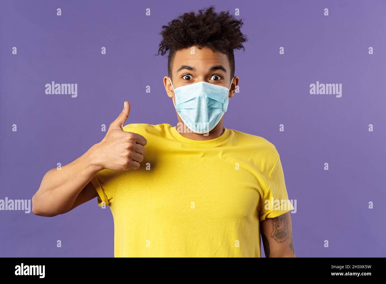 Covid19, healtcare and medicine concept. Excited young hispanic man in facial mask taking care of health, avoid public places, s Stock Photo