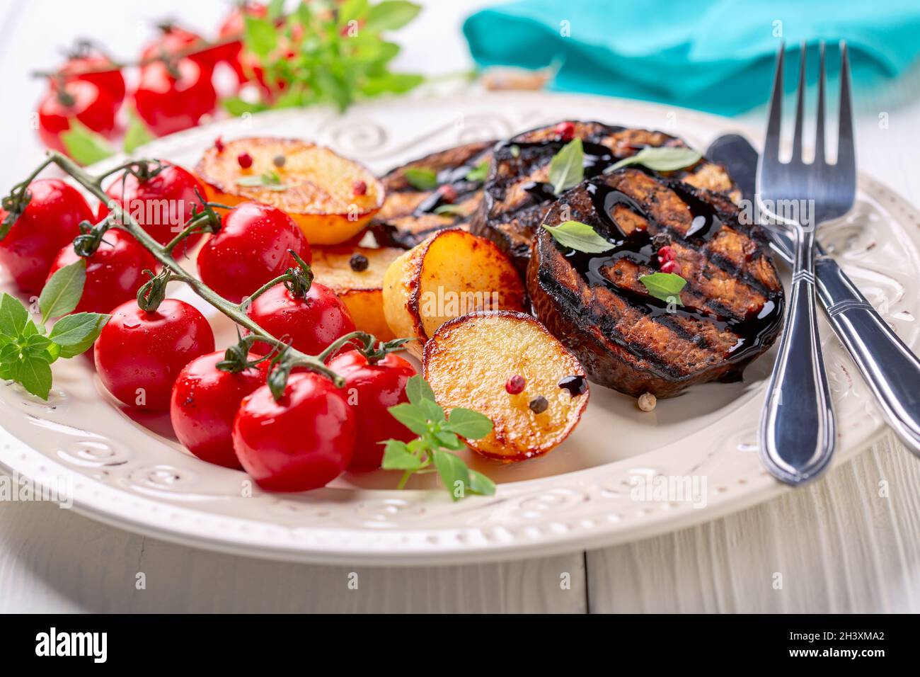 Delicious grilled eggplant steaks with vegetables. Stock Photo