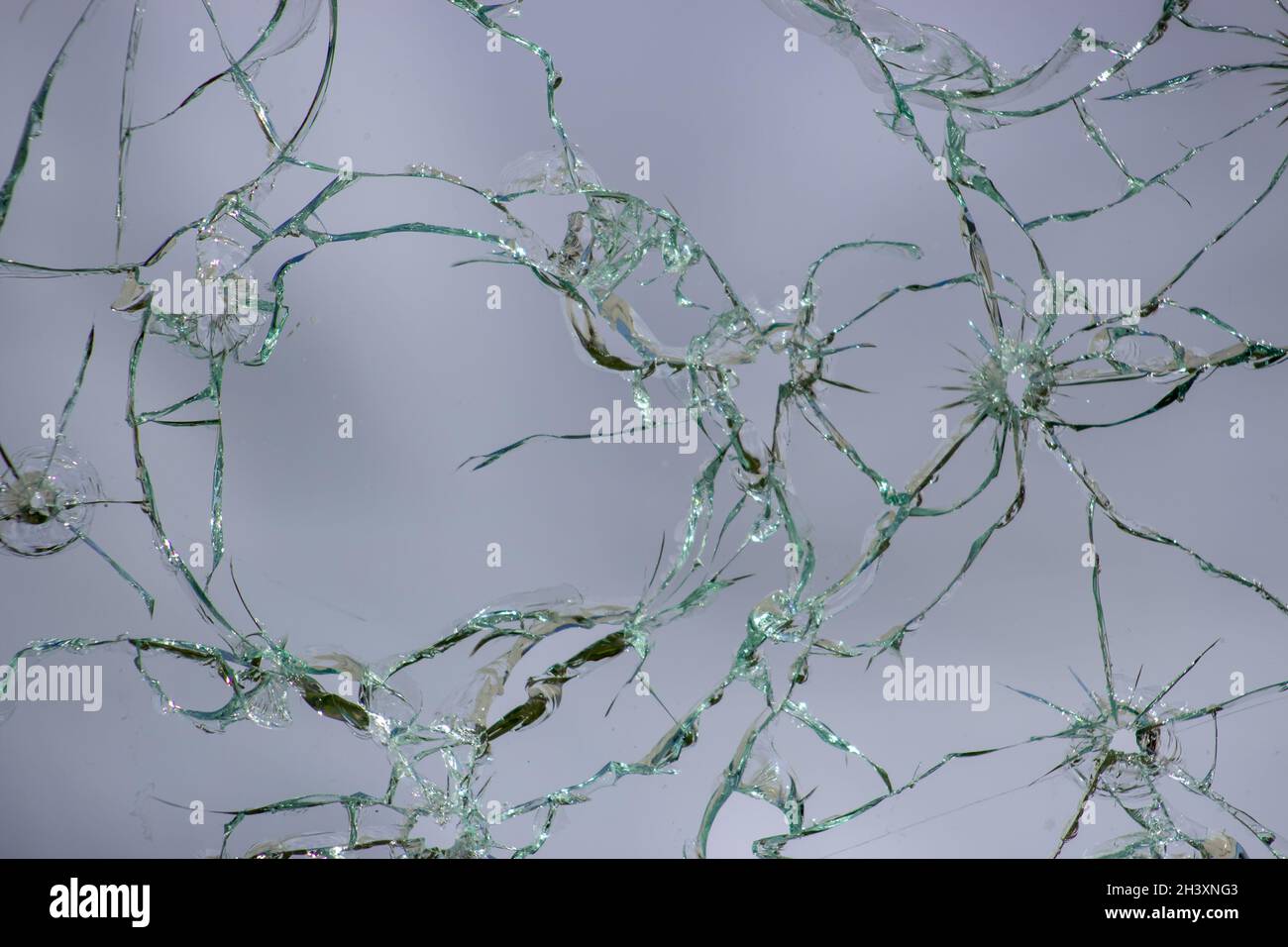 Cracked glass, texture of broken shots of glass on a white background. Stock Photo