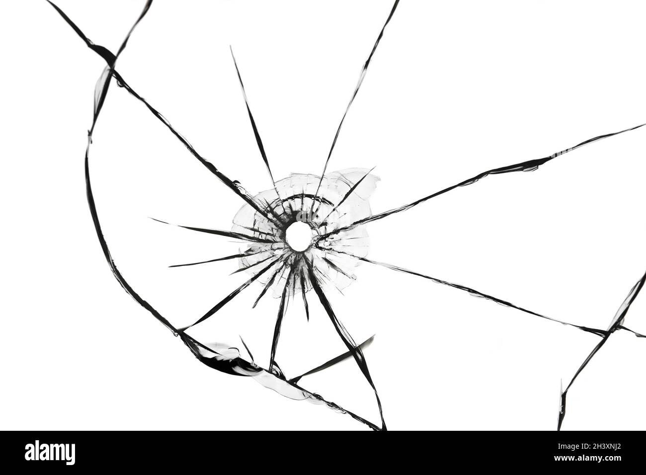 The effect of cracks on broken glass from a shot of a weapon. A hole in the glass of the bullet. Stock Photo