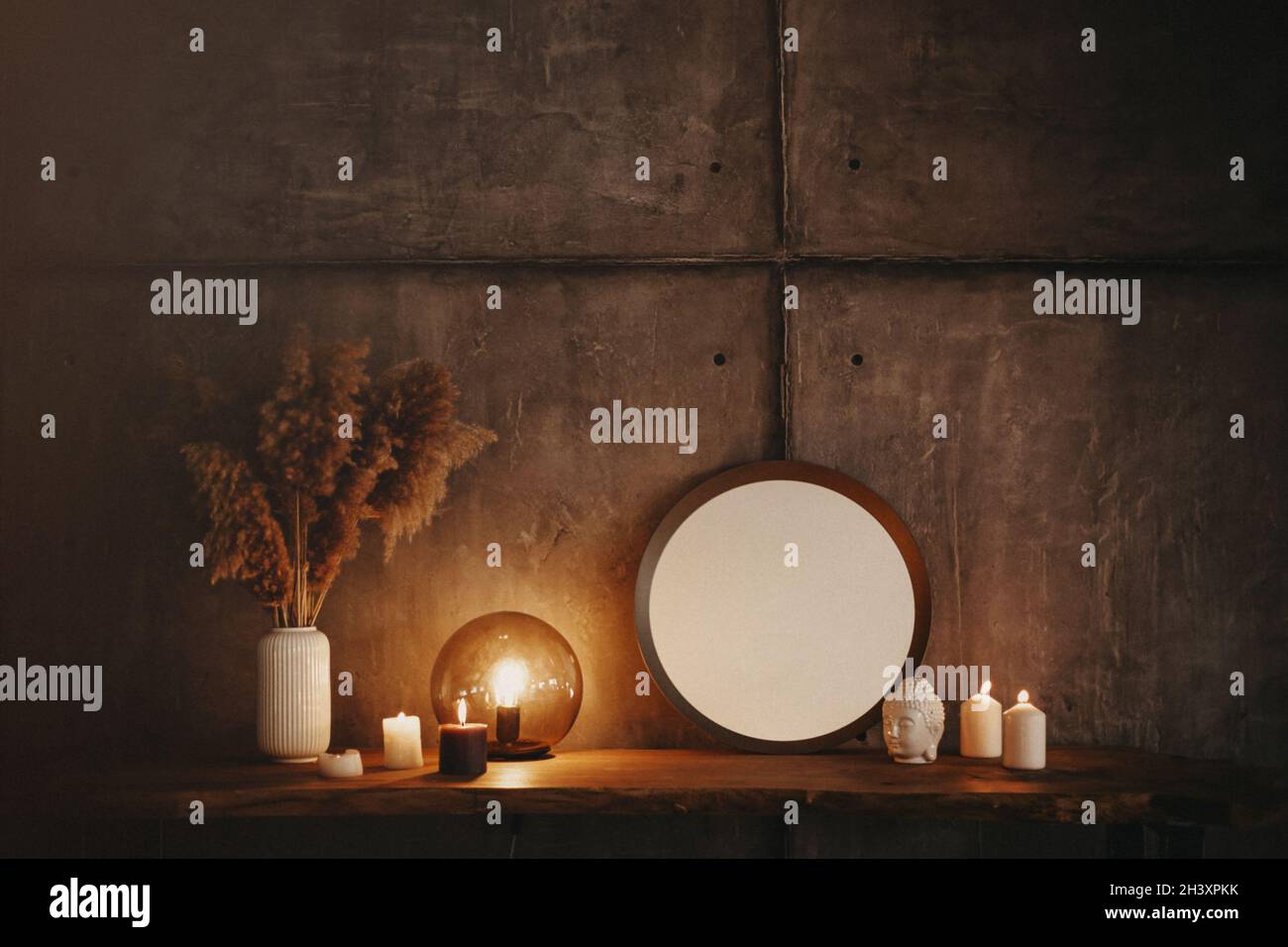 Round mirror on wooden shelf with two burning candles and small