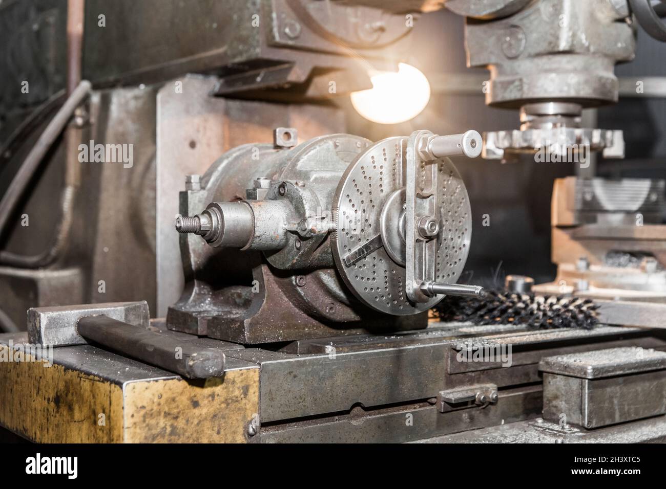 Old milling machine with working lighting closeup equipment in the shop of an industrial