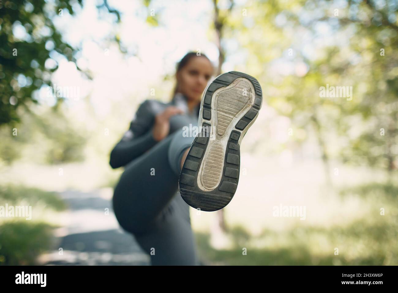 Girl kicking with her leg in camera, sole close up. Foreground focus. Stock Photo