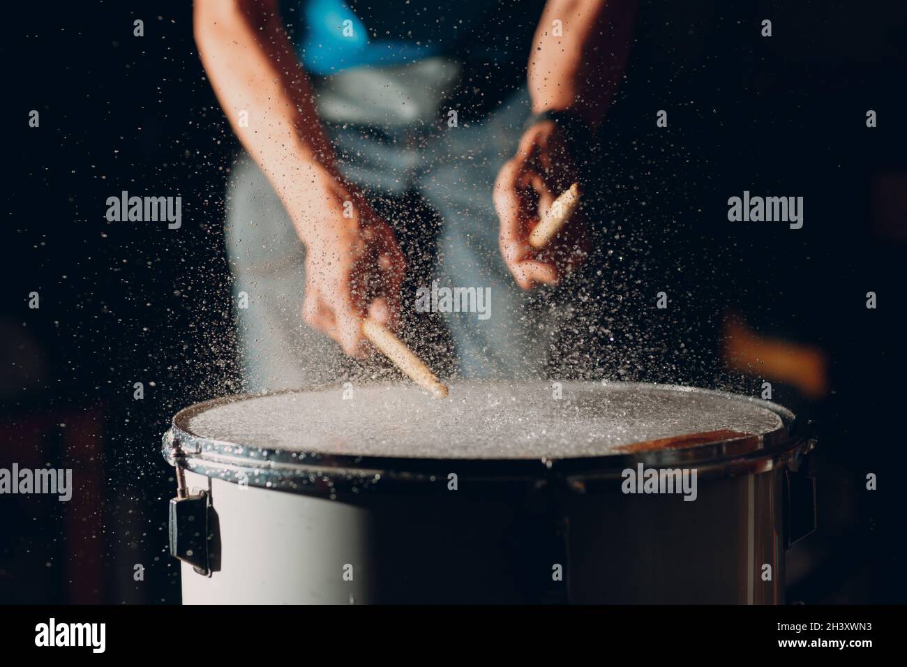 Drum sticks drumming beat rhythm on drum surface with splash water