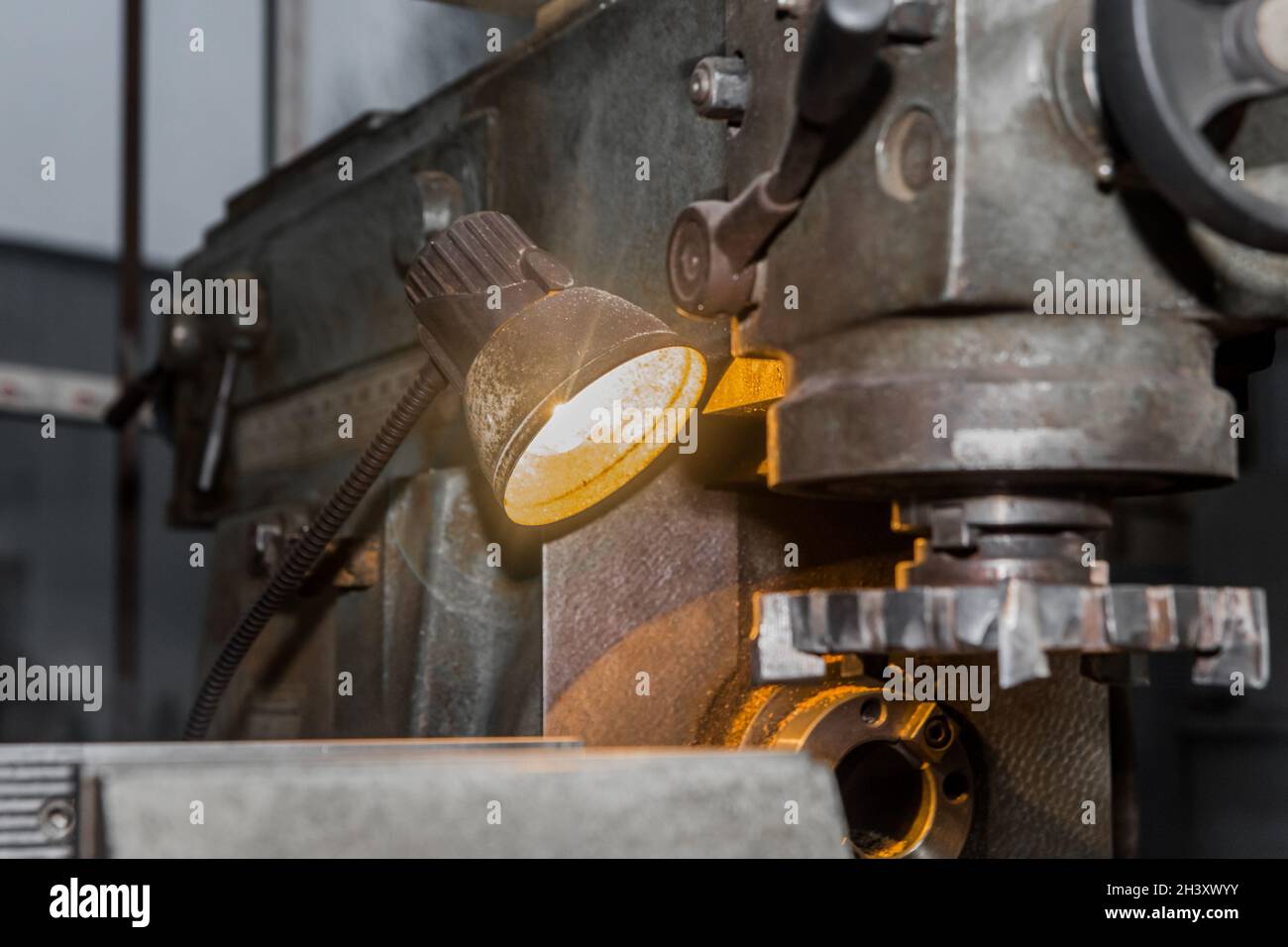 Industrial lighting element lamp for an old milling machine in the production hall. Stock Photo