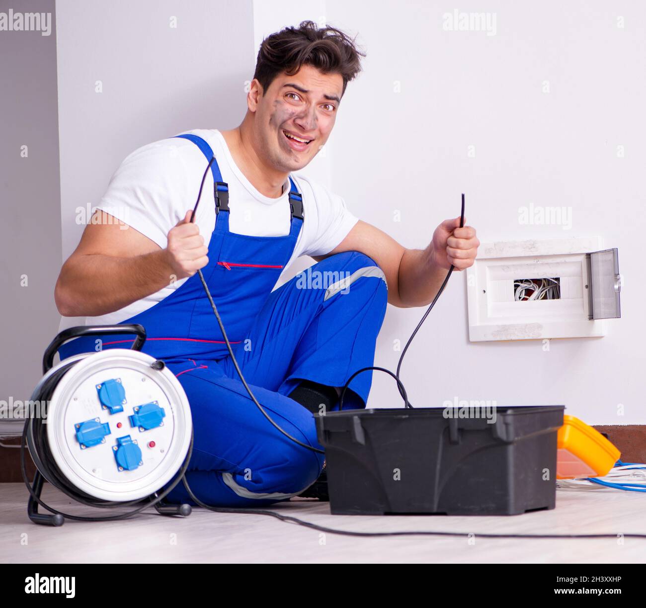 Funny Man doing electrical repairs at home Stock Photo