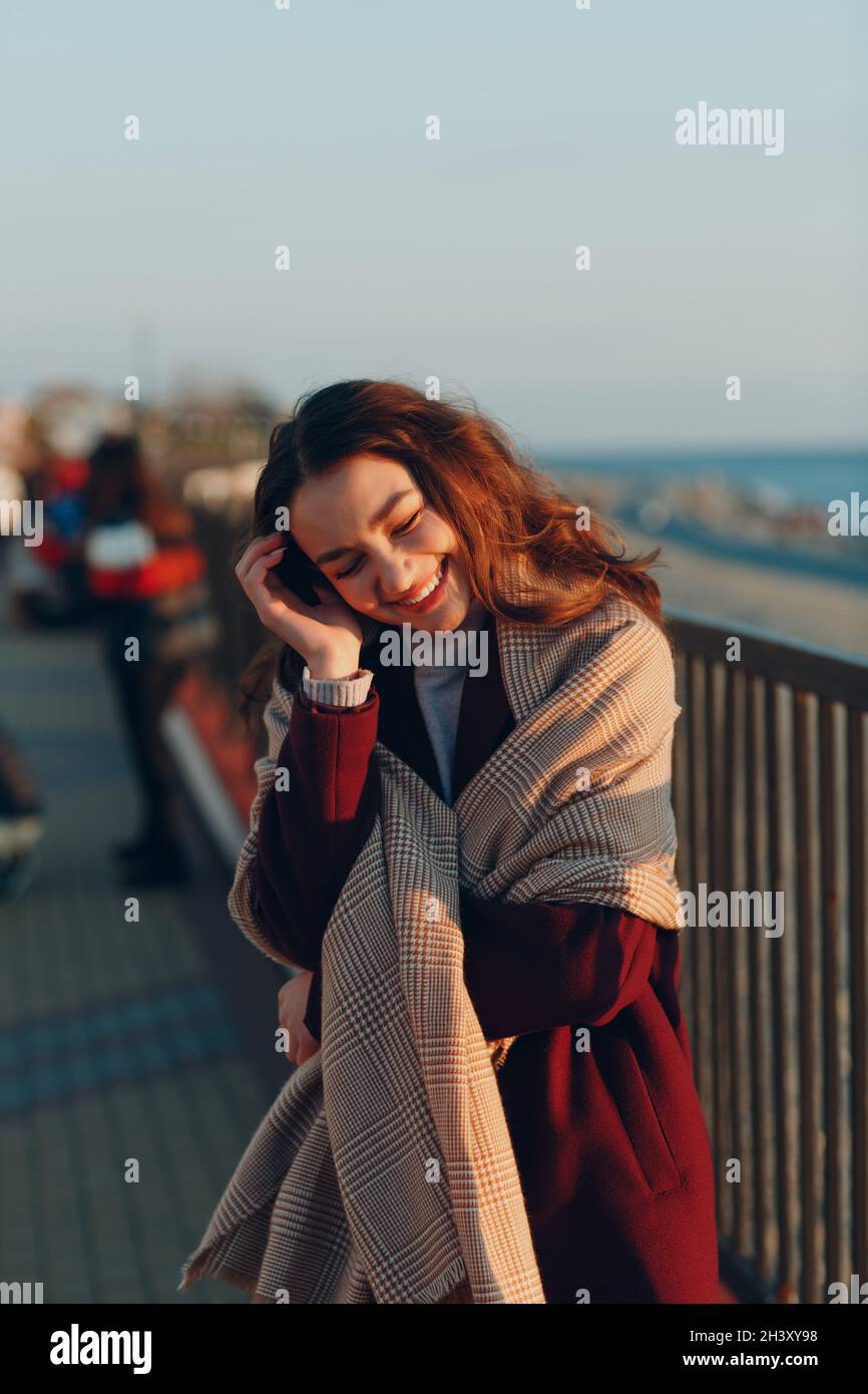 Young woman in coat at coast outdoors. Stock Photo