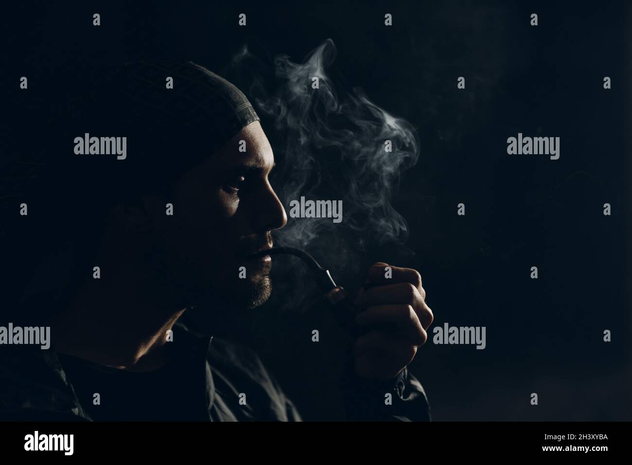 Man Smoking A Pipe On Dark Background Back Lit Profile Portrait Stock