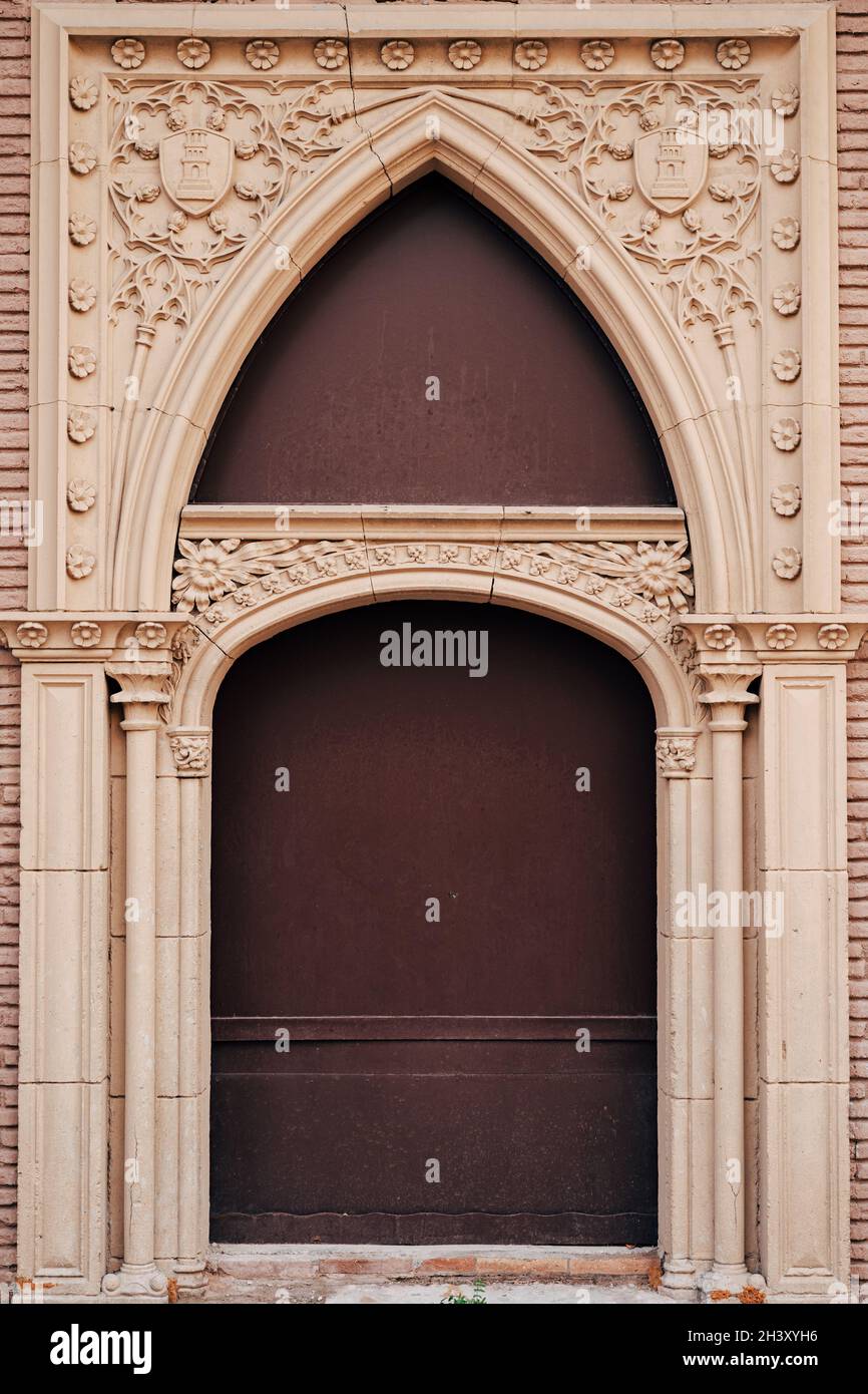 Brown original doors with patterns and columns and arch and hand sculpting Stock Photo