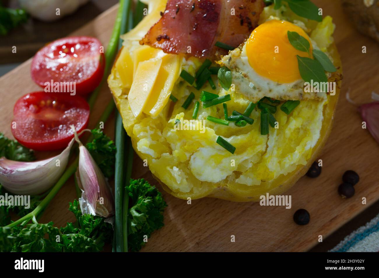 Tasty potato stuffed with eggs, bacon, cheese Stock Photo