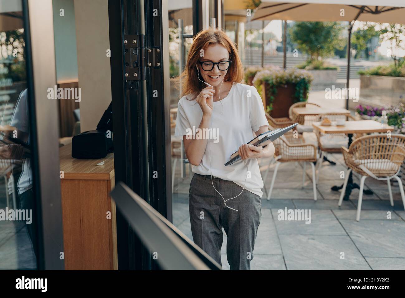 Ginger European woman talks via video chat app uses modern gadgets