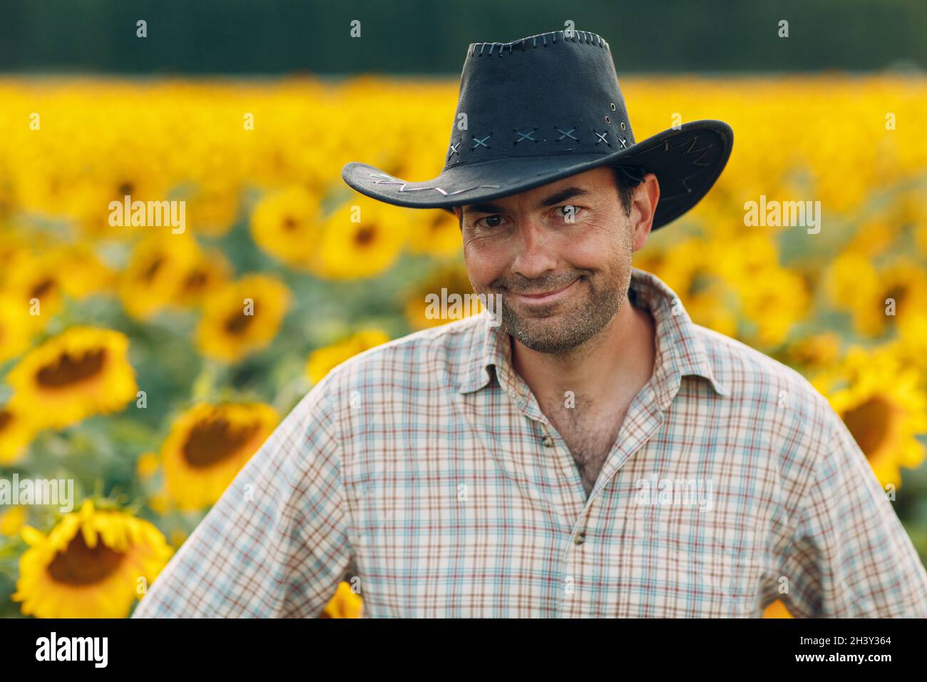 Man farmer smile and standing in a sunflower field Stock Photo - Alamy