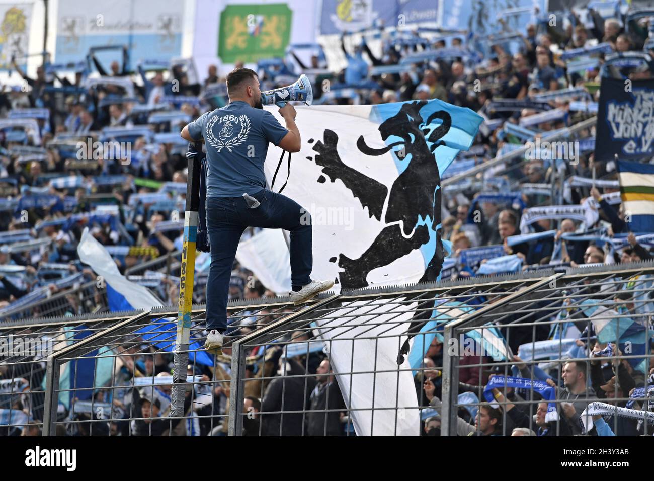 Muenchen GRUENWALDER STADION. 30th Oct, 2021. 1860 fans, football fans,  whip with megaphone. 1860 fans, football fans in a good mood, atmosphere  football 3rd division, Liga3, TSV Munich 1860-SC Freiburg II 6-0