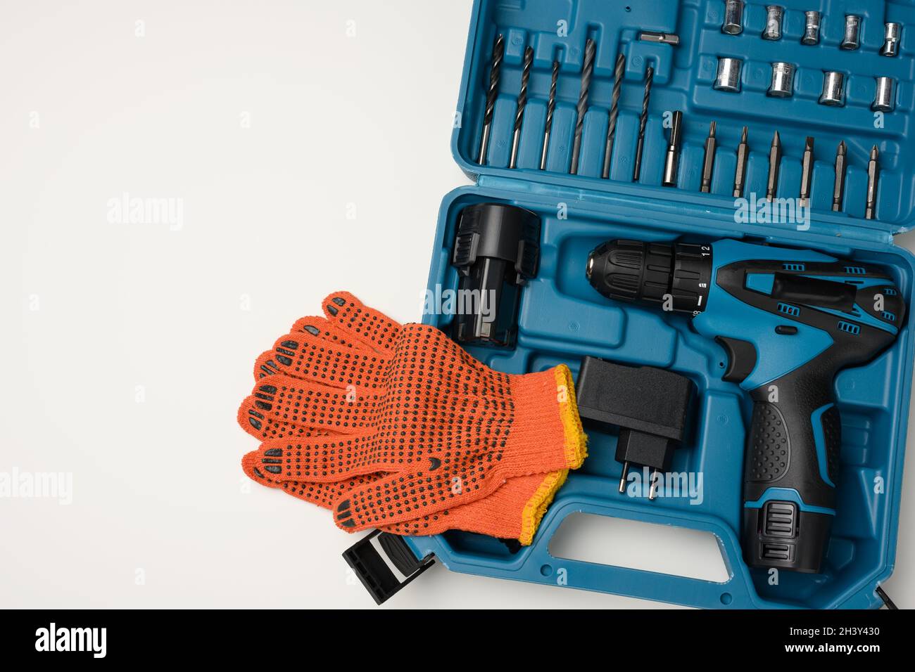 Plastic box with cordless drill and set of drills and screwdrivers on